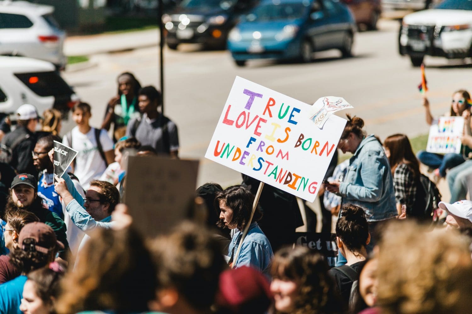Protest photo with woman holding sign saying "True Love is Born from Understanding