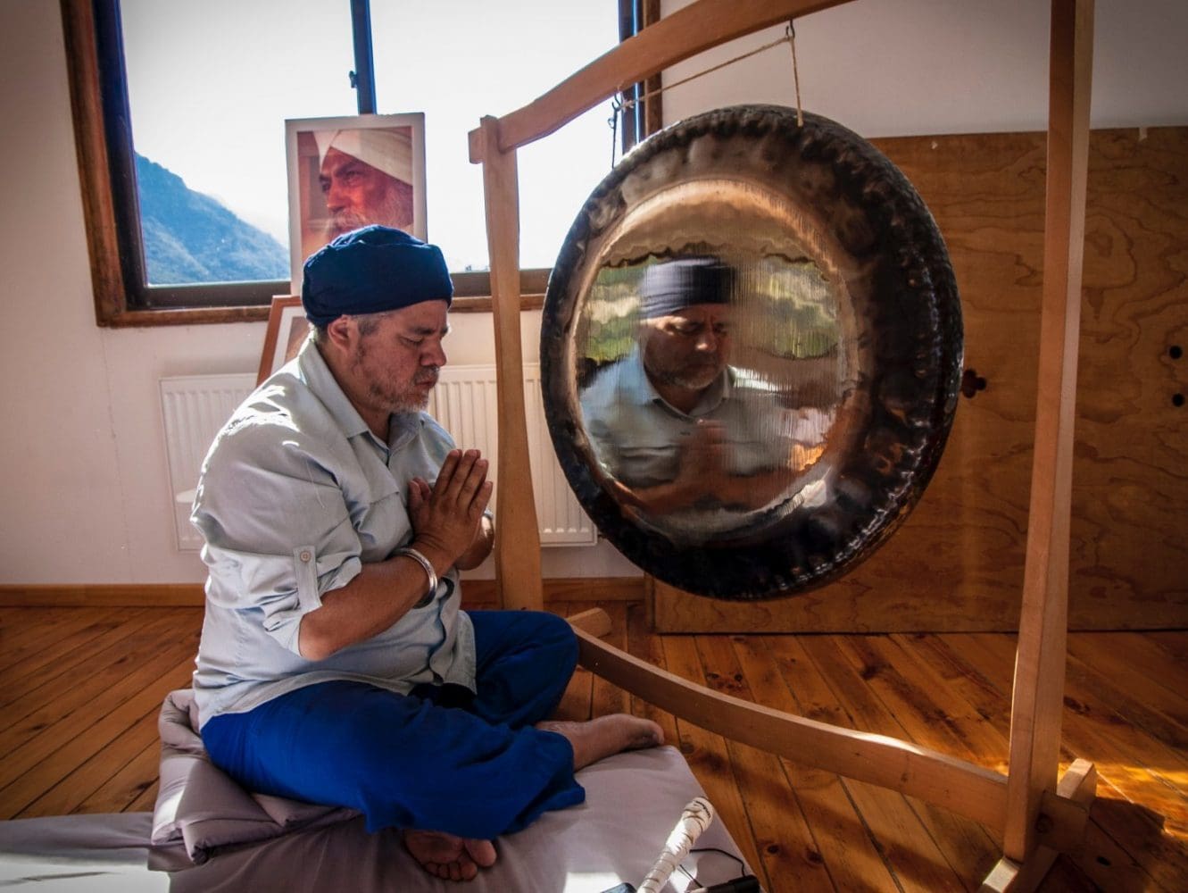 Man seated in front of gong